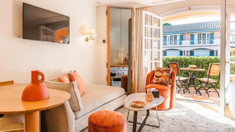 una sala de estar con sofÃ¡ y mesa en Hotel Le Domaine de L Astragale Saint Tropez en Saint-Tropez