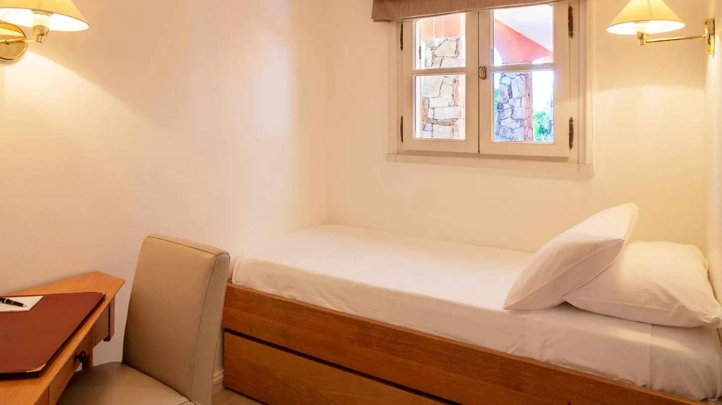 un dormitorio pequeÃ±o con cama y ventana en Hotel Le Domaine de L Astragale Saint Tropez en Saint-Tropez