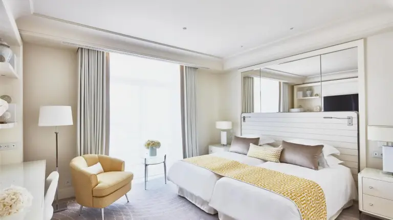 ein Schlafzimmer mit einem groÃen Bett mit einem groÃen Spiegel im HÃ´tel Martinez