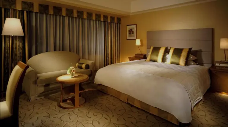 una habitaciÃ³n de hotel con una cama grande y una silla en el Hotel Okura Kyoto en Kioto