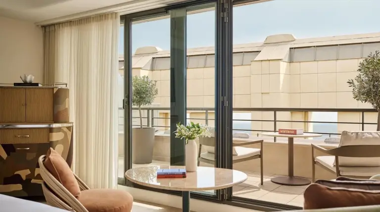 a white bedroom with a bed and a window at Hotel Palais de la Mediterranee