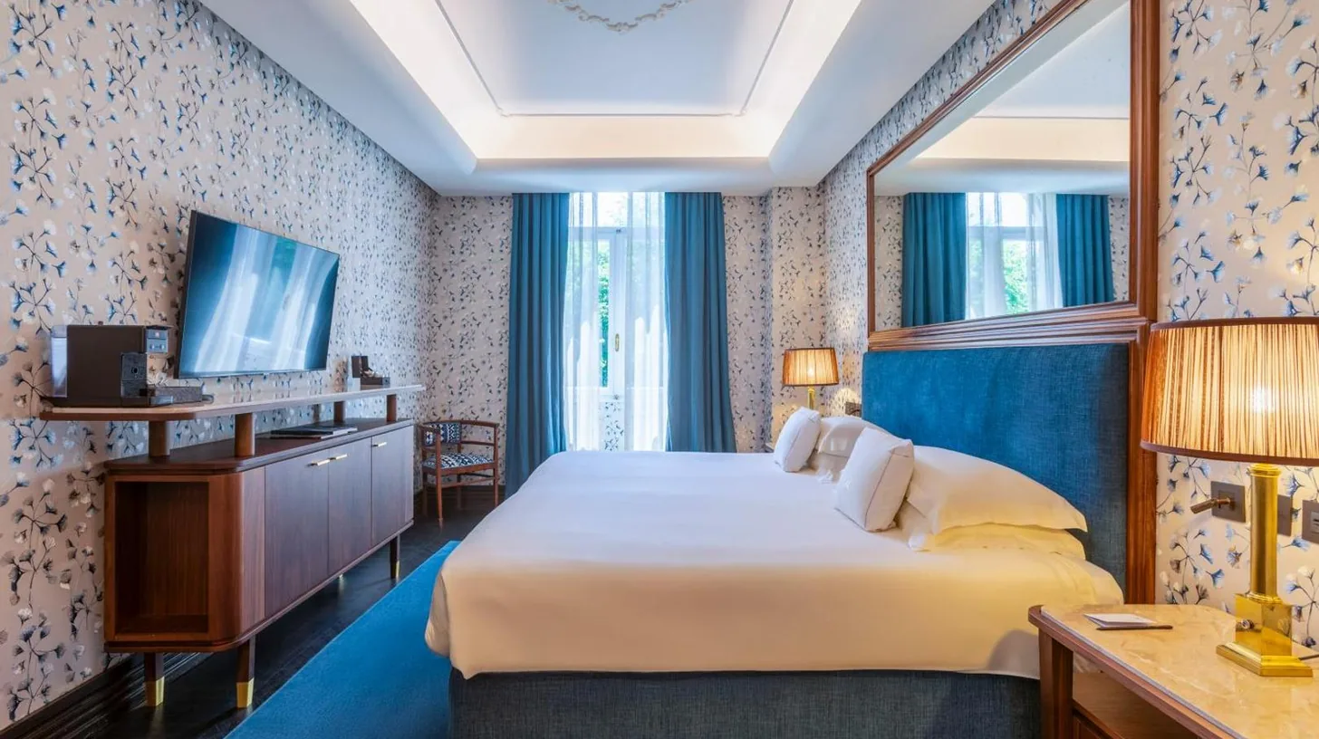 ein Hotelzimmer mit einem Bett und einem Fernseher im Hotel Regency - Small Luxury Hotels of the World in Florenz
