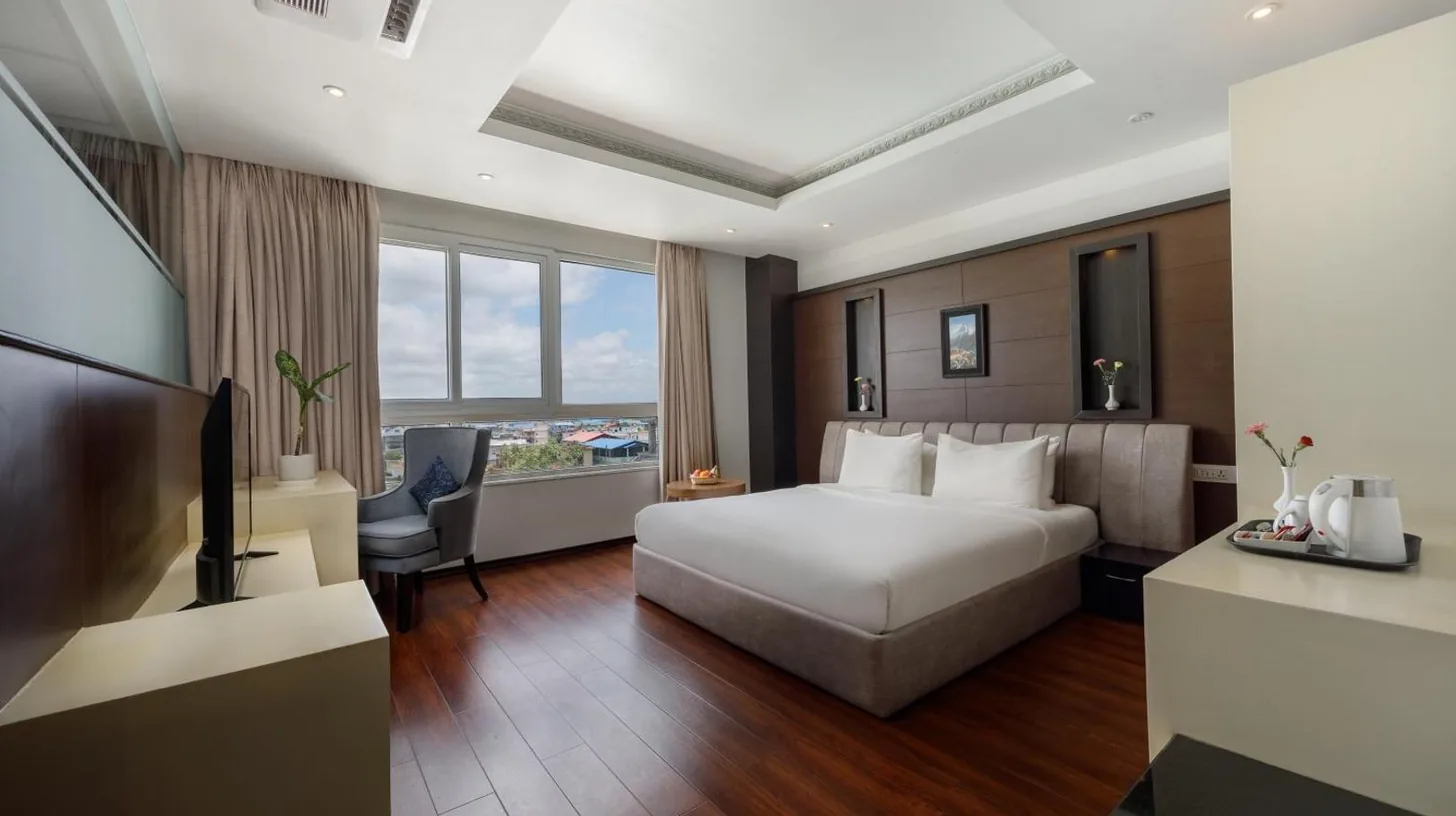 une chambre d'hÃ´tel avec un lit et un bureau Ã  l'Hotel The Kingsbury Ã  Birtamod