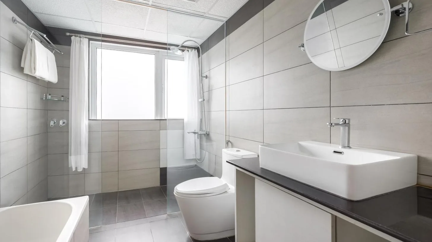 une salle de bains avec un lavabo, des toilettes et un miroir Ã  l'Hotel The Kingsbury Ã  Birtamod