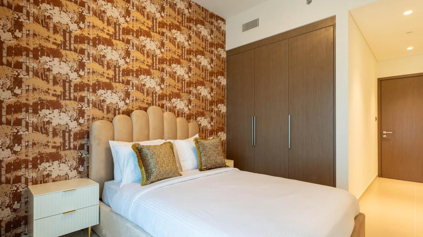 una habitaciÃ³n con una cama blanca grande y una pared de ladrillo en INA Homes - Act 1 Full Burj Khalifa and Fountain Views en DubÃ¡i