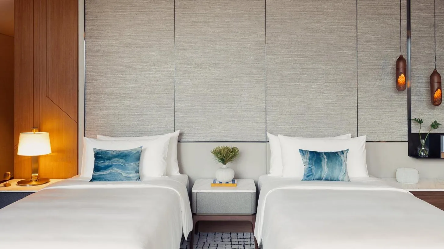 dos camas una al lado de la otra en una habitaciÃ³n en Kimpton Maa-Lai Bangkok by IHG en Bangkok