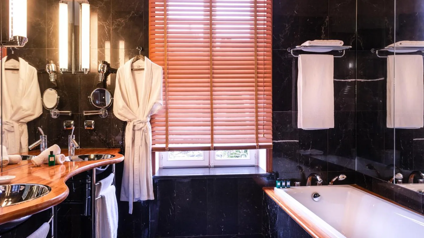 a bathroom with two sinks and a bath tub at L'Hôtel in Beaune