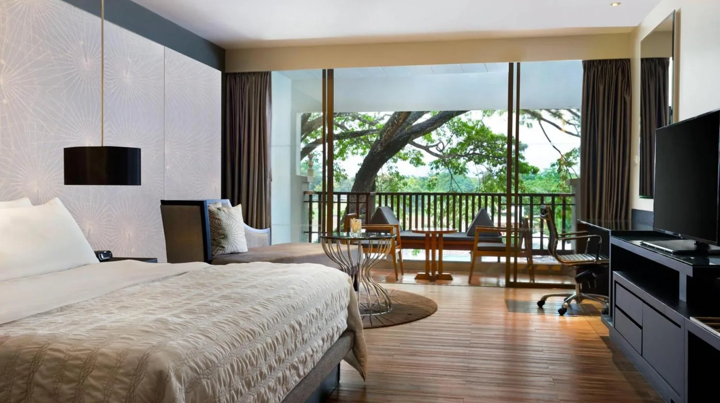 a black lamp on a wall next to a bed at Le Meridien Chiang Rai Resort