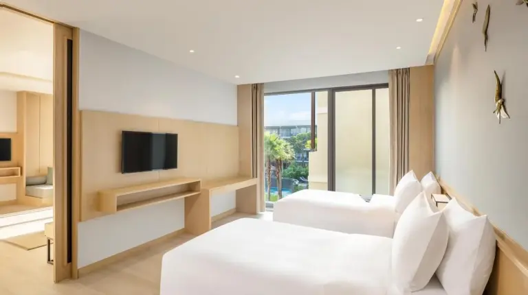 une chambre d'hôtel avec deux lits et une télévision au Le Meridien Khao Lak Resort & Spa à Khao Lak