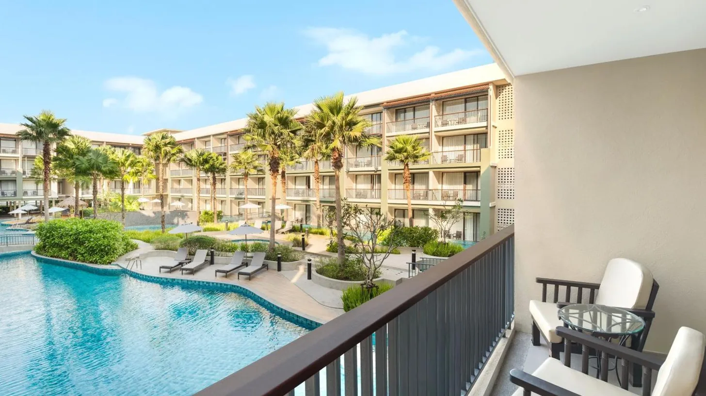 une vue de la piscine depuis le balcon d'un resort au Le Meridien Khao Lak Resort & Spa à Khao Lak