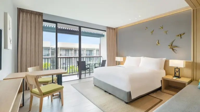 une chambre avec un grand lit blanc et un salon au Le Meridien Khao Lak Resort & Spa à Khao Lak