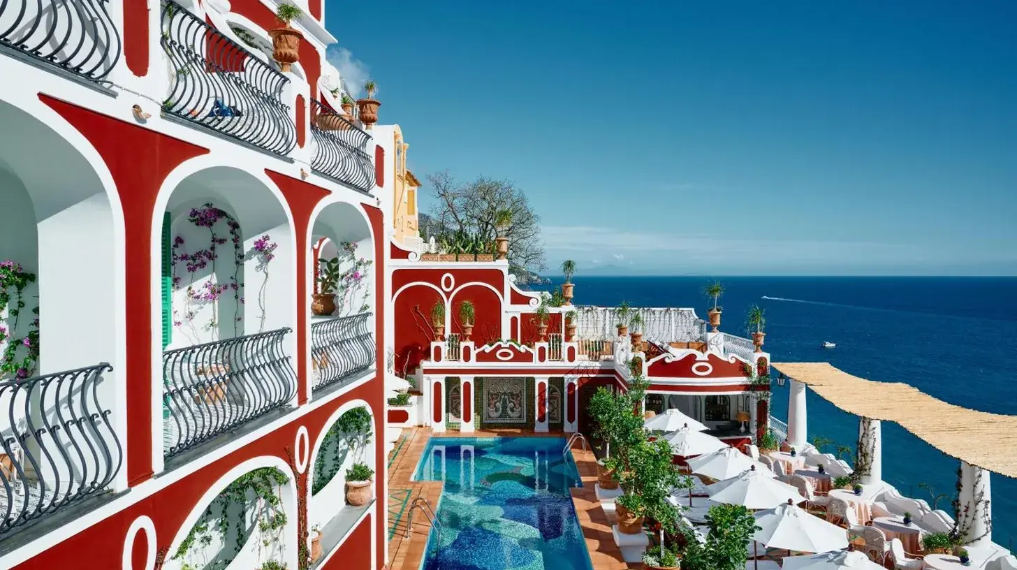 a building with a swimming pool next to the ocean at Le Sirenuse in Positano