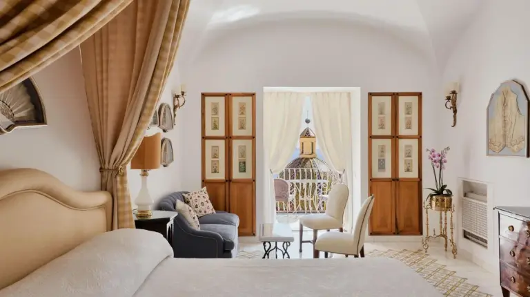 a bedroom with a bed and a living room at Le Sirenuse in Positano