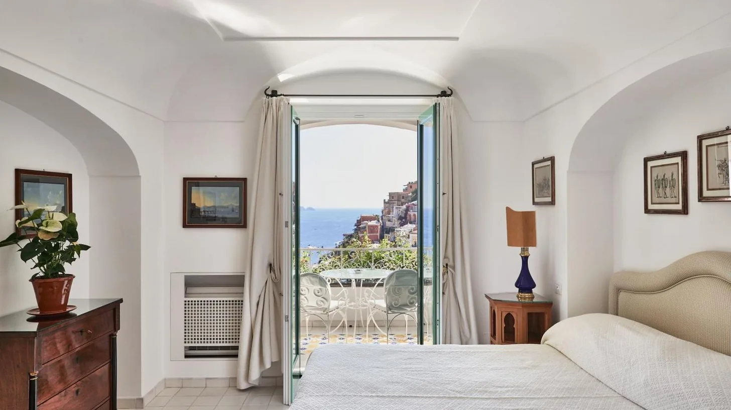 a bedroom with a bed and a view of the ocean at Le Sirenuse in Positano