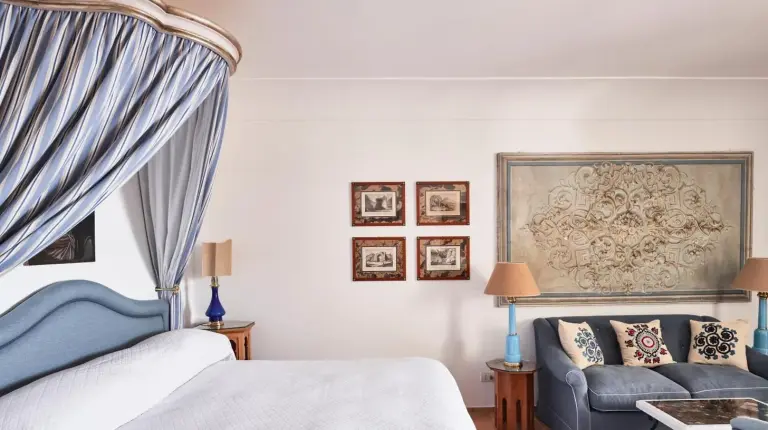a bedroom with a bed and a couch at Le Sirenuse in Positano