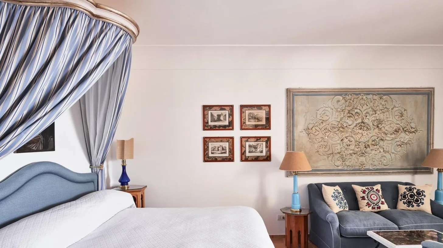 a bedroom with a bed and a couch at Le Sirenuse in Positano