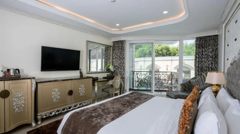 a bedroom with a large bed and a television at LK Emerald Beach - SHA Extra Plus in Pattaya North