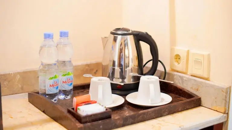 a kitchen counter with a tea kettle and bottles of water at Lorin Solo Hotel in Solo