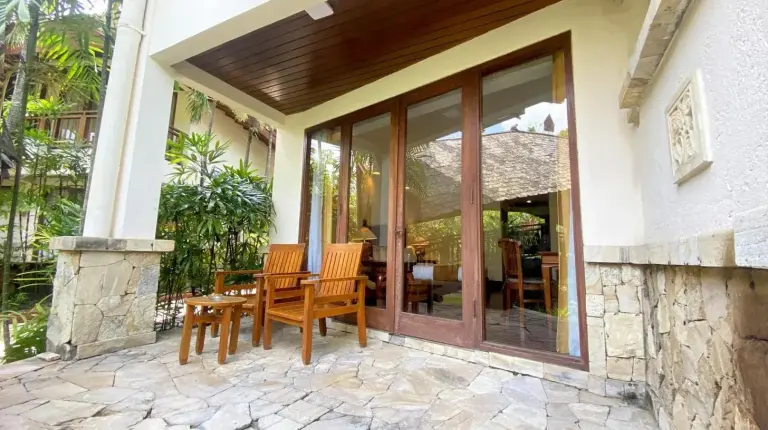 a porch with sliding glass doors with a table and chairs at Lorin Solo Hotel in Solo
