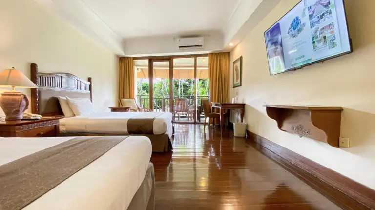 a hotel room with two beds and a flat screen tv at Lorin Solo Hotel in Solo