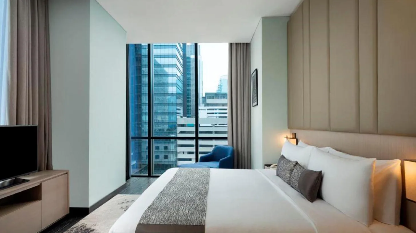 a hotel room with a large bed and a large window at Mangkuluhur Residences by Lorin in Jakarta
