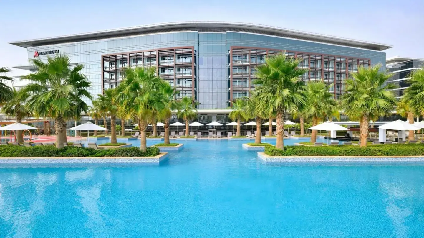 un gran edificio con palmeras delante en el Marriott Hotel Al Forsan