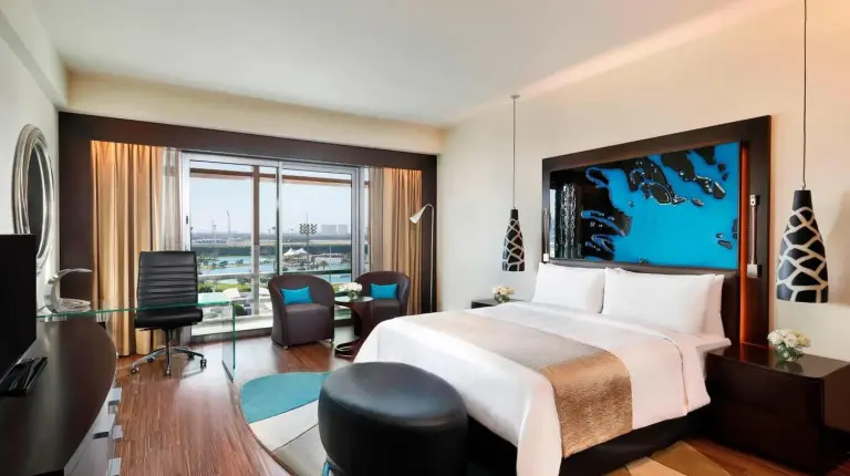 una habitaciÃ³n de hotel con una cama grande y un balcÃ³n en el Marriott Hotel Al Forsan