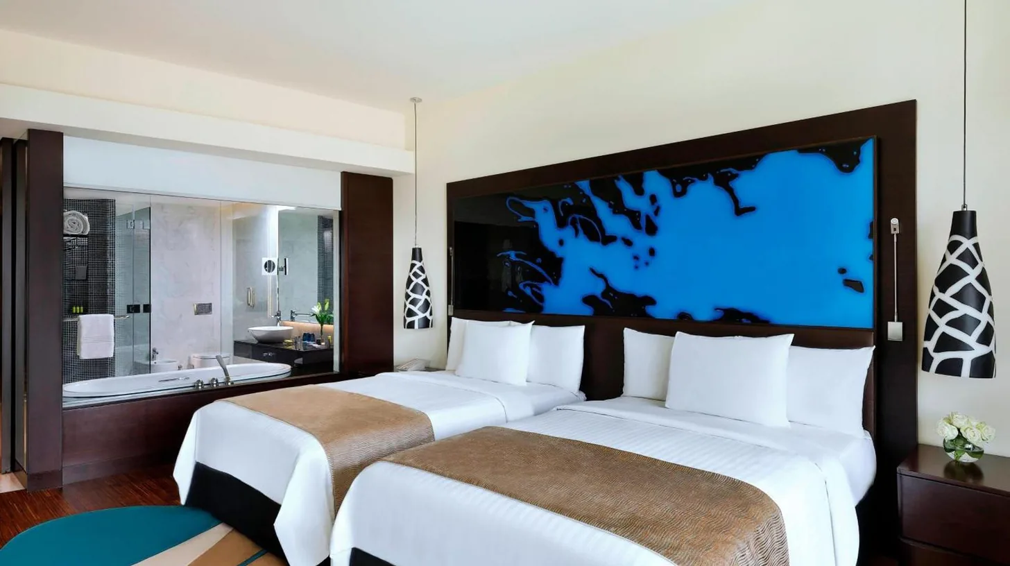 una habitaciÃ³n de hotel con una cama grande y un escritorio en el Marriott Hotel Al Forsan