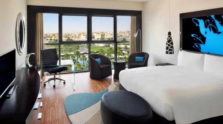 una habitaciÃ³n de hotel con dos camas y un escritorio en el Marriott Hotel Al Forsan