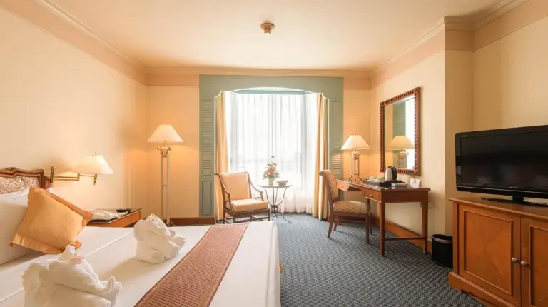 una habitaciÃ³n de hotel con cama y televisiÃ³n en Montien Riverside Hotel Bangkok en Bangkok