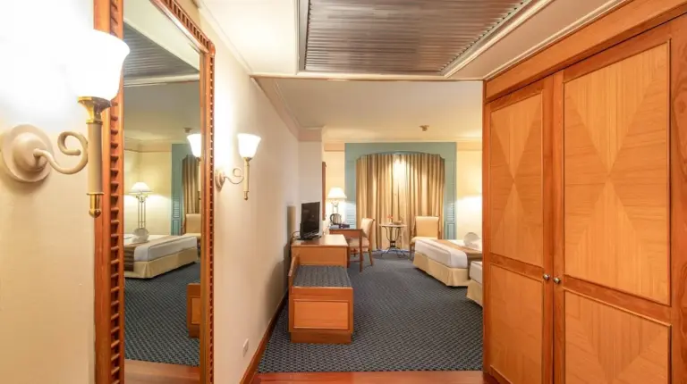 un pasillo de una habitaciÃ³n de hotel con dormitorio en Montien Riverside Hotel Bangkok en Bangkok