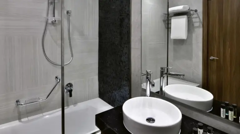 a bathroom with a sink and a shower and a tub at Mövenpick Hotel Apartments Downtown Dubai in Dubai