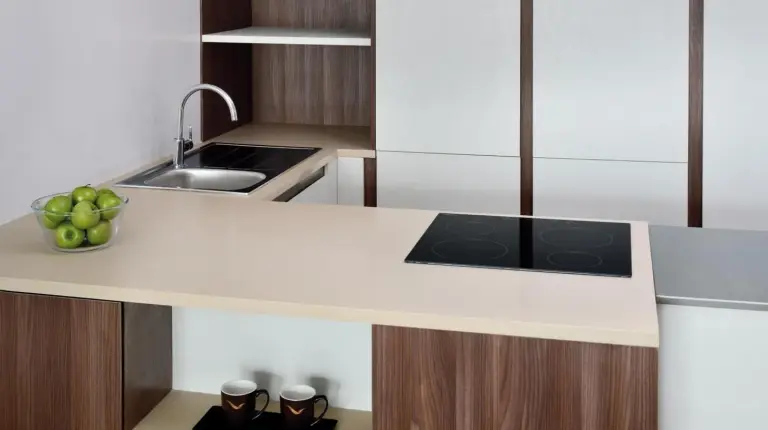 a kitchen with a white counter with a bowl of apples at Mövenpick Hotel Apartments Downtown Dubai in Dubai