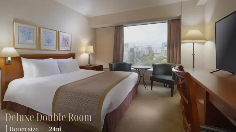 a hotel room with a bed and a large window at Nagoya Kanko Hotel in Nagoya