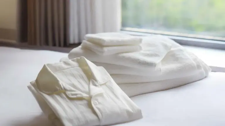 two white towels on a bed with a window at Nagoya Kanko Hotel in Nagoya