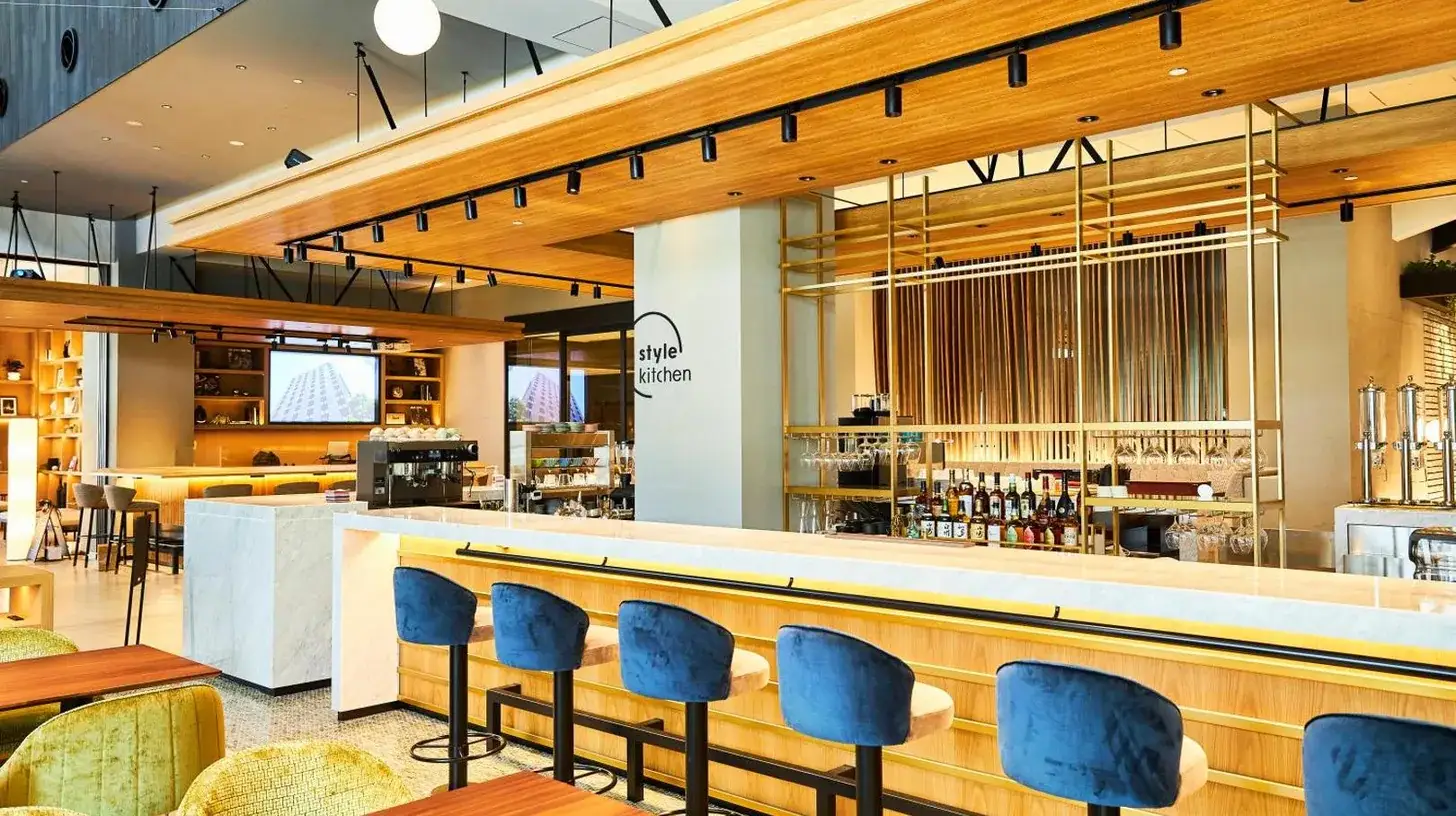 a restaurant with blue chairs and a bar at Nikko Style Nagoya in Nagoya
