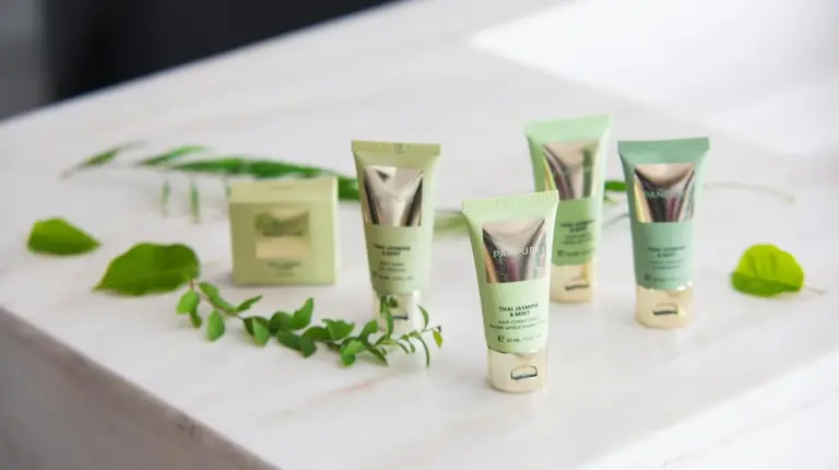 a group of four tubes of moisturizers on a table with plants at Nikko Style Nagoya in Nagoya
