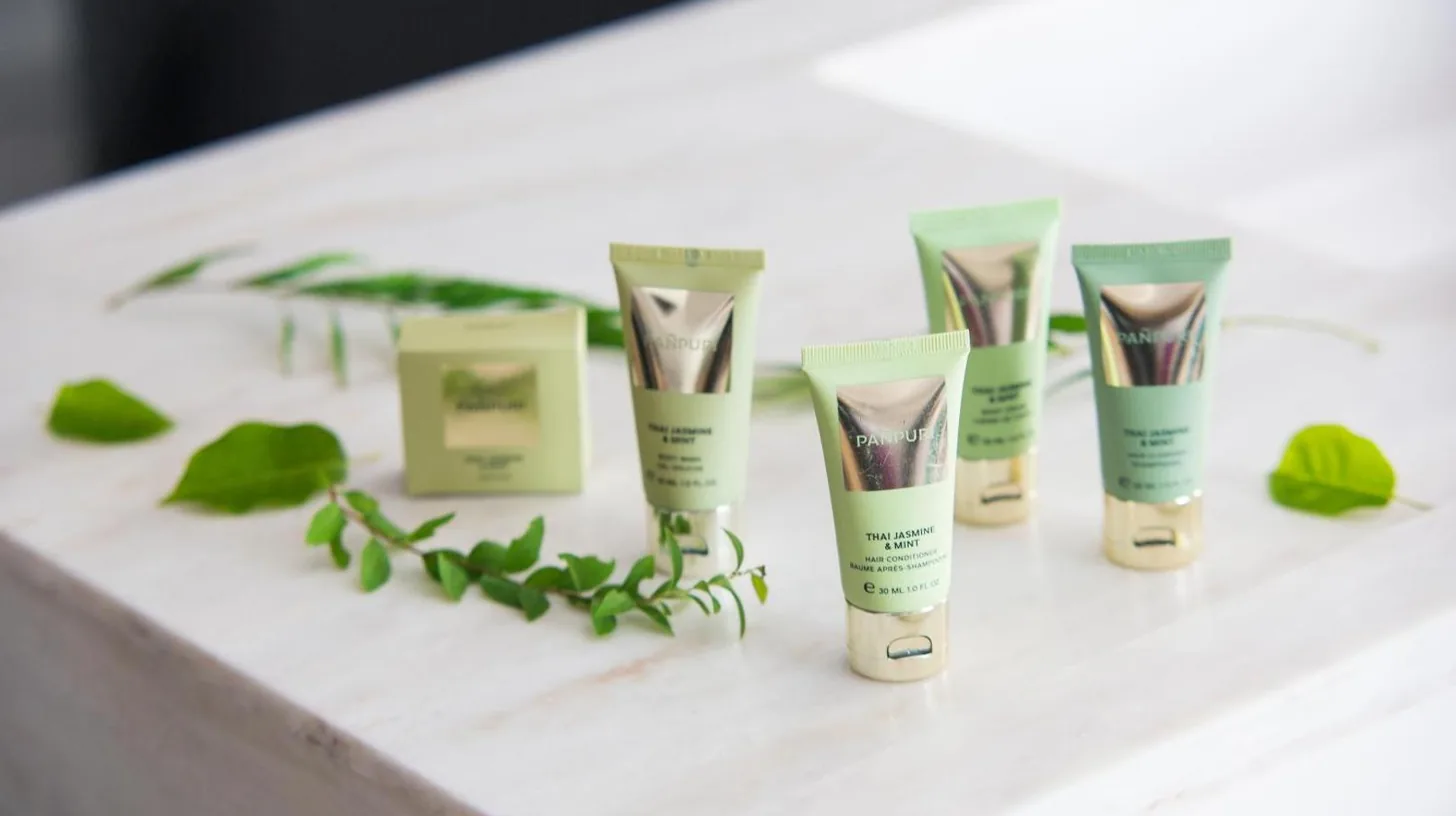a group of four tubes of moisturizers on a table with plants at Nikko Style Nagoya in Nagoya