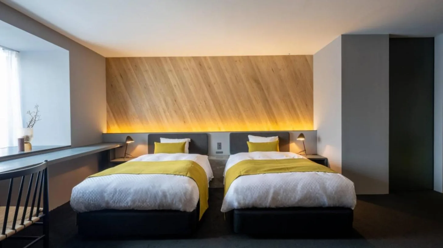 a bedroom with two beds with yellow sheets at NIPPONIA HOTEL Hakodate Port Town in Hakodate