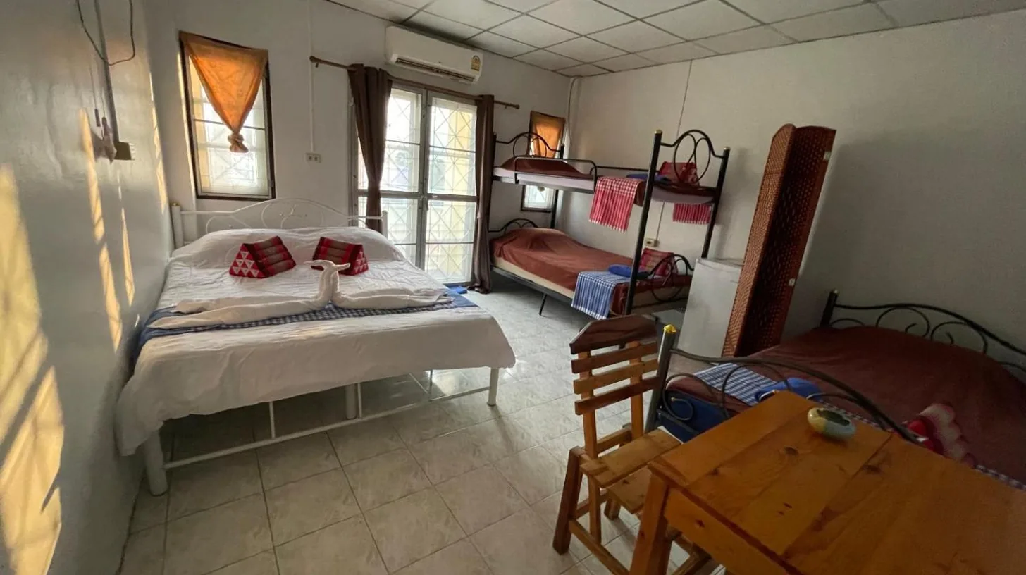 a bedroom with a bed and a desk in a room at Noot's Guesthouse in Kanchanaburi