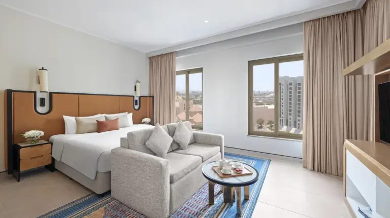 ein Hotelzimmer mit einem groÃen Bett und einem Fernseher im Oaks Ibn Battuta Gate Dubai in Dubai
