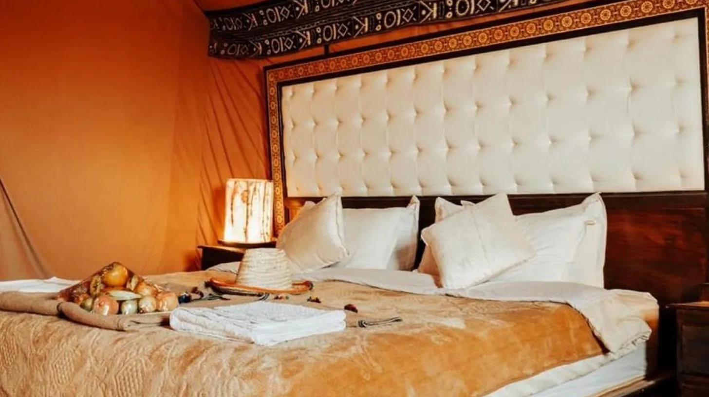 une chambre avec un grand lit dans une piÃ¨ce Ã  l'Oasis Mirage Luxury Camp Ã  Merzouga
