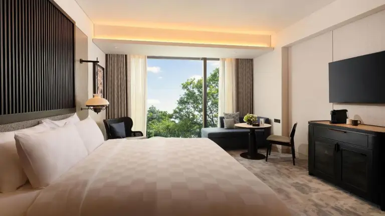 a hotel room with a large bed and a large window at Padma Hotel Semarang in Semarang