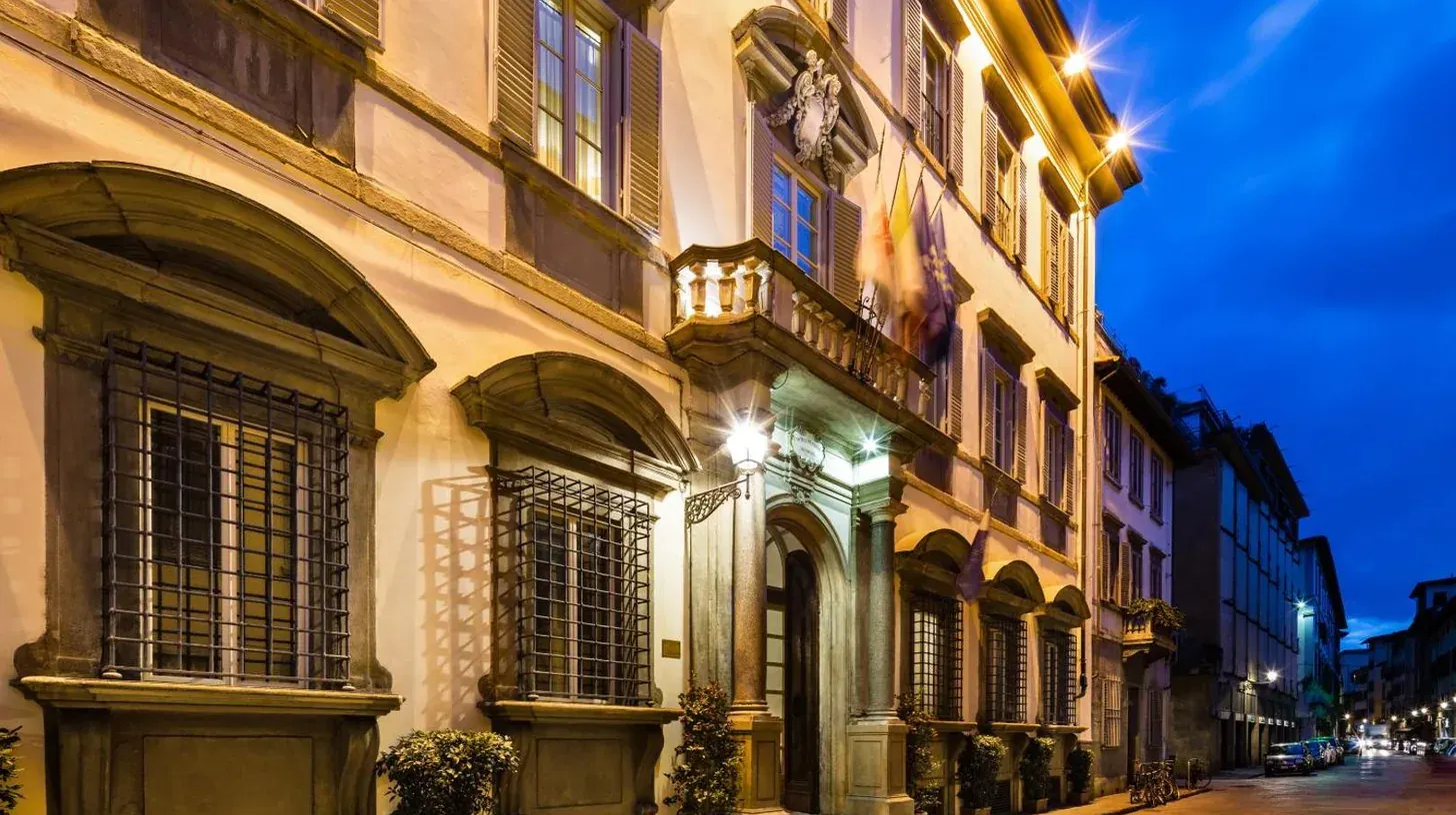 ein GebÃ¤ude auf einer StraÃe bei Nacht mit Lichtern im Palazzo Firenze by Baglioni Hotels & Resorts in Florenz