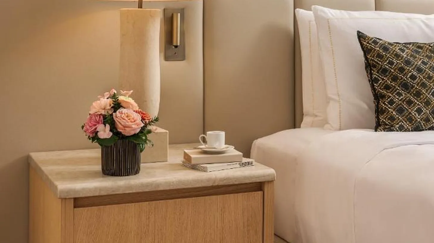 a bed with a table with a lamp on it at Park Hyatt Milano in Milan