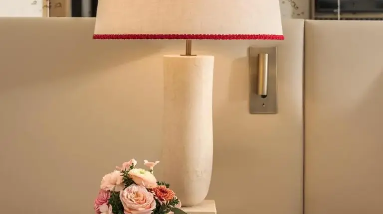 a lamp on a table with a vase of flowers at Park Hyatt Milano in Milan
