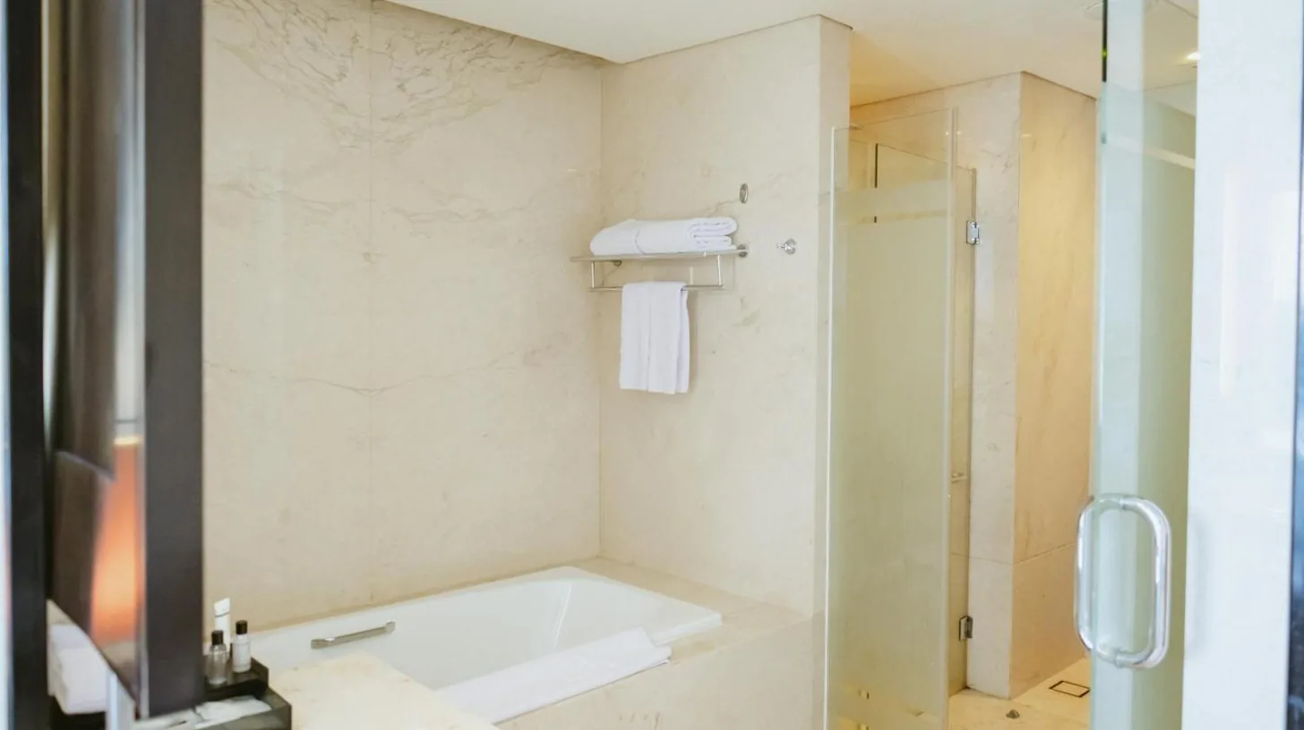 a bathroom with a tub and a shower at PO Hotel Semarang in Semarang