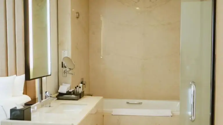 a hotel room with a large bed and a television at PO Hotel Semarang in Semarang
