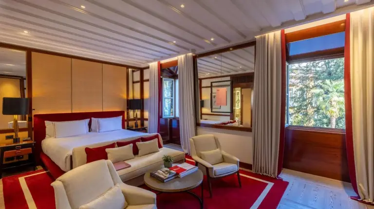 a bedroom with a bed and two chairs and a table at Portrait Milano - Lungarno Collection in Milan