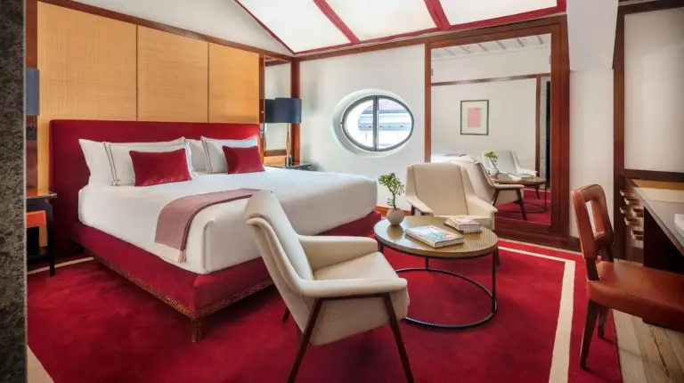 a bedroom with a large bed and a table and chairs at Portrait Milano - Lungarno Collection in Milan